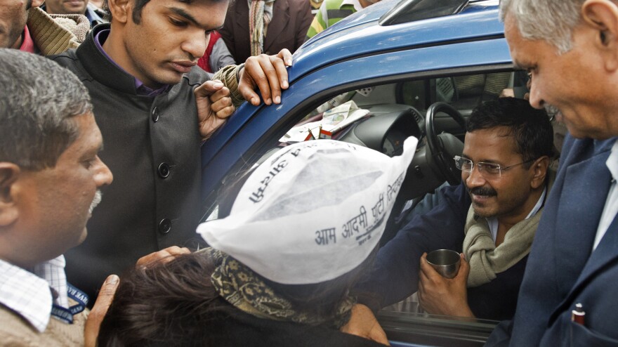 Delhi Chief Minister Arvind Kejriwal (center) greets supporters from his blue wagon, which became a de facto local government headquarters during a two-day protest in New Delhi.