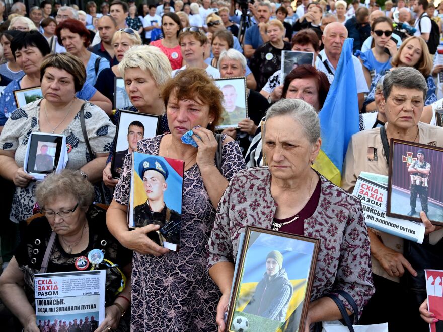 Mothers and widows of Ukrainian servicemen hold pictures of their relatives during a memorial rally in front of the Russian embassy in Kyiv, Ukraine's capital, in August.