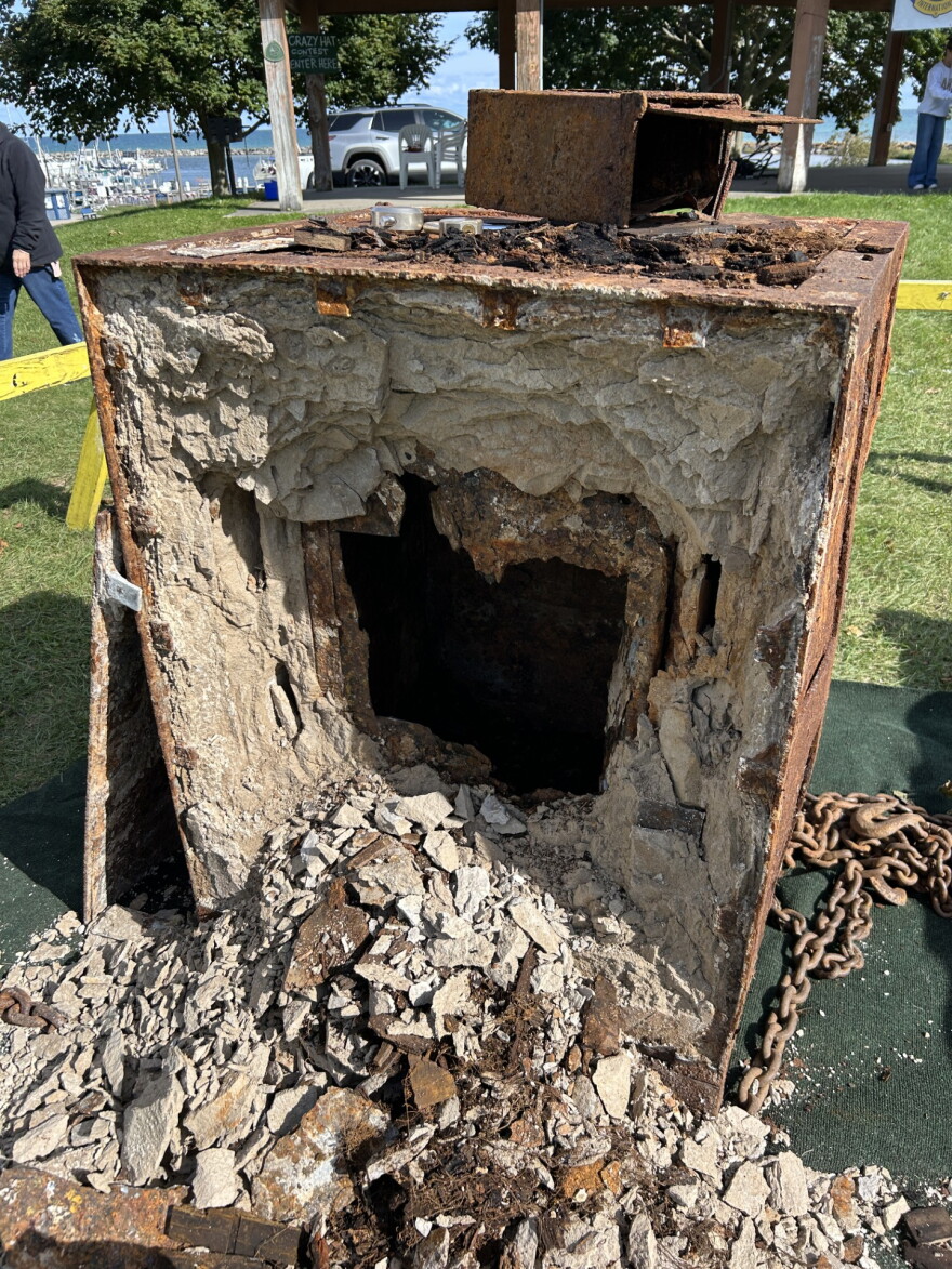 The backside of the 100-year-old safe after safe crackers drilled, hammered and picked their way inside. Inside they found a metal box full of burnt wood.