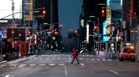 A woman walks through an almost-deserted Times Square in New York City. Why did New York and Seattle have such different responses to the pandemic? 