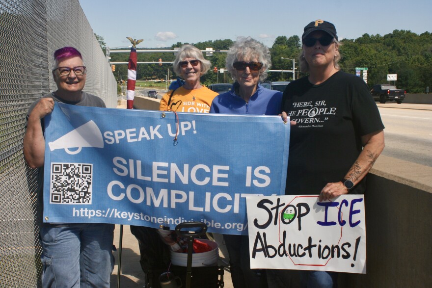 Dotty Delafield, of Boalsburg (left), and other members of Keystone Indivisible rallied against actions by U.S. Immigration and Customs Enforcement Friday, Aug. 22, on the Waddle Road walkway over Interstate 99 in Patton Township, Centre County.