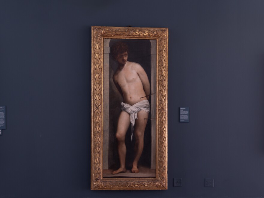 The work attributed to Titian hangs between two other paintings of Saint Sebastian in the gallery of Belen Jesuit Preparatory School in Miami.