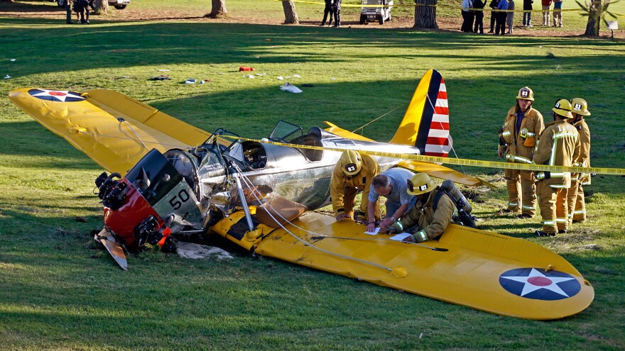 Officials work on the scene of a vintage airplane that had been piloted by actor Harrison Ford when it crash-landed in March on the Penmar Golf Course in the Venice area of Los Angeles. Federal safety investigators have concluded that a problem with a carburetor part led to engine failure.