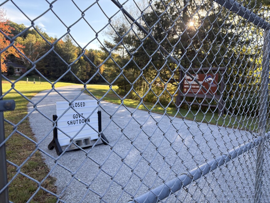 A sign that reads "Closed, Govnt Shutdown" behind a chain link fence