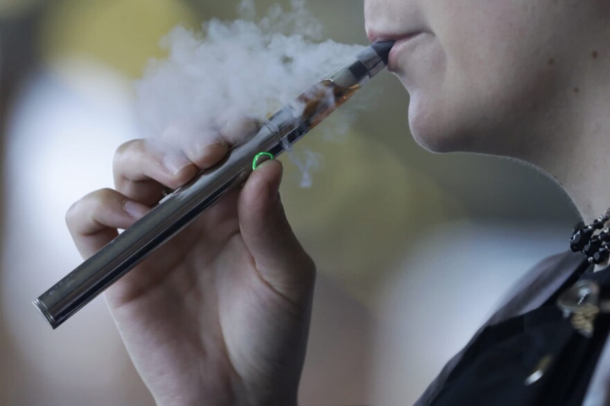 A woman uses an electronic cigarette. (Tony Dejak/AP)