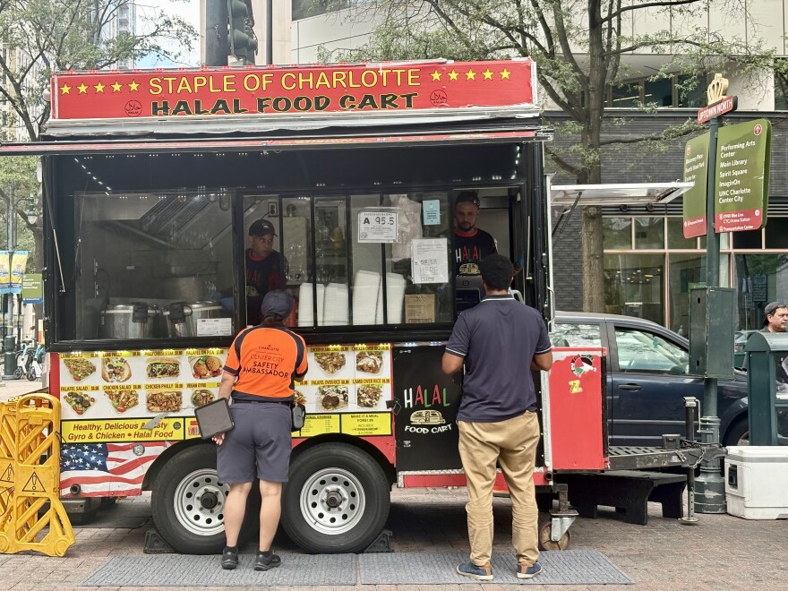 Lunchtime customers order plates from the Halal Food Cart at the corner of Trade and Tryon Streets in uptown Charlotte.