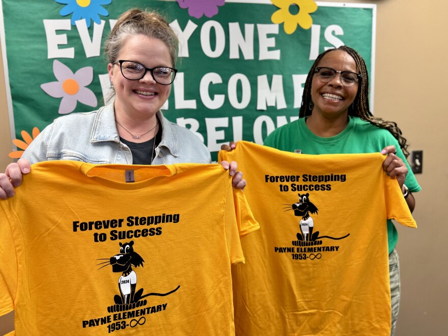 Payne Elementary School Principal Tina Young, right, and office administrator Kelsey Gillenwater hand out commemorative T-shirts to students, teachers and alumni visiting the school. Payne is one of six Wichita schools closing for good at the end of this school year.