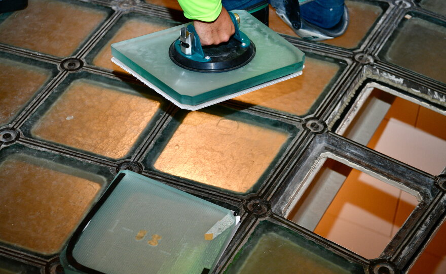 Workers putting glass in the floor. 