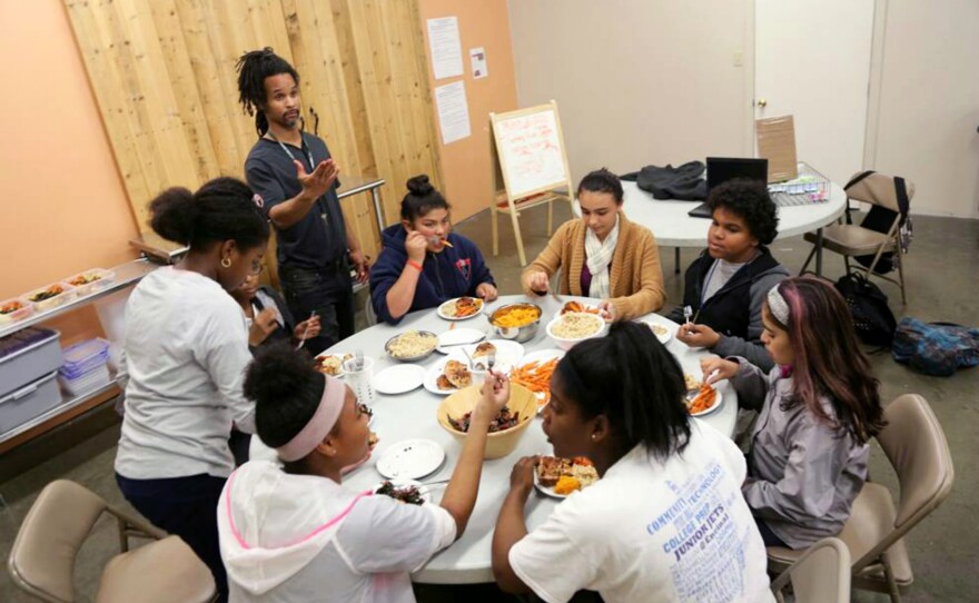 Teen volunteers eat together after they finish cooking meals for a local hospital.