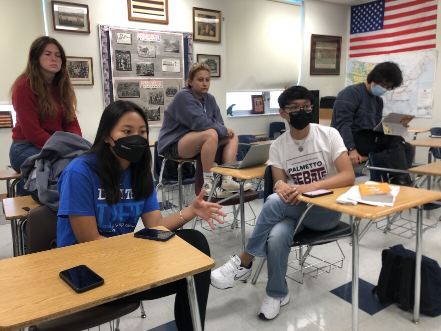 Anna Liu, co-president of the Miami Palmetto Senior High School speech and debate club gives feedback to a student as others listen on.