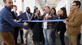Lenny Speiller, the mayor's Director of Communications hands off the ceremonial scissors to Executive Director Juancarlos Soto as the New Haven Pride Center staff members and elected officials celebrate the ribbon cutting of the center's new space.