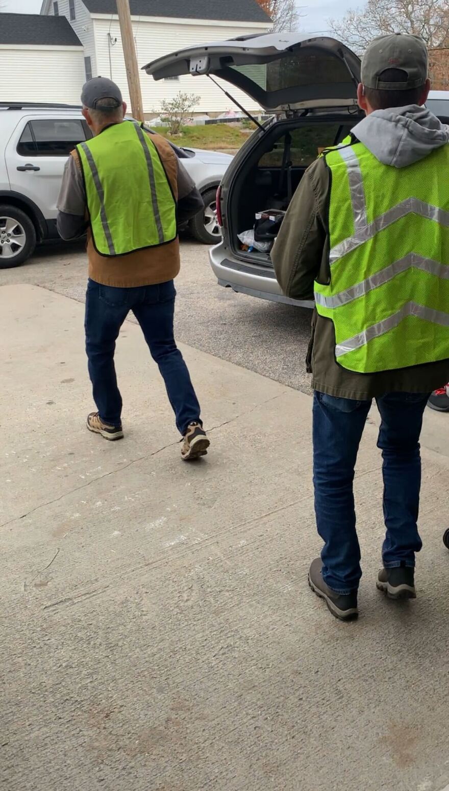 Volunteers bringing grocery bags out to cars. Also from RICAN