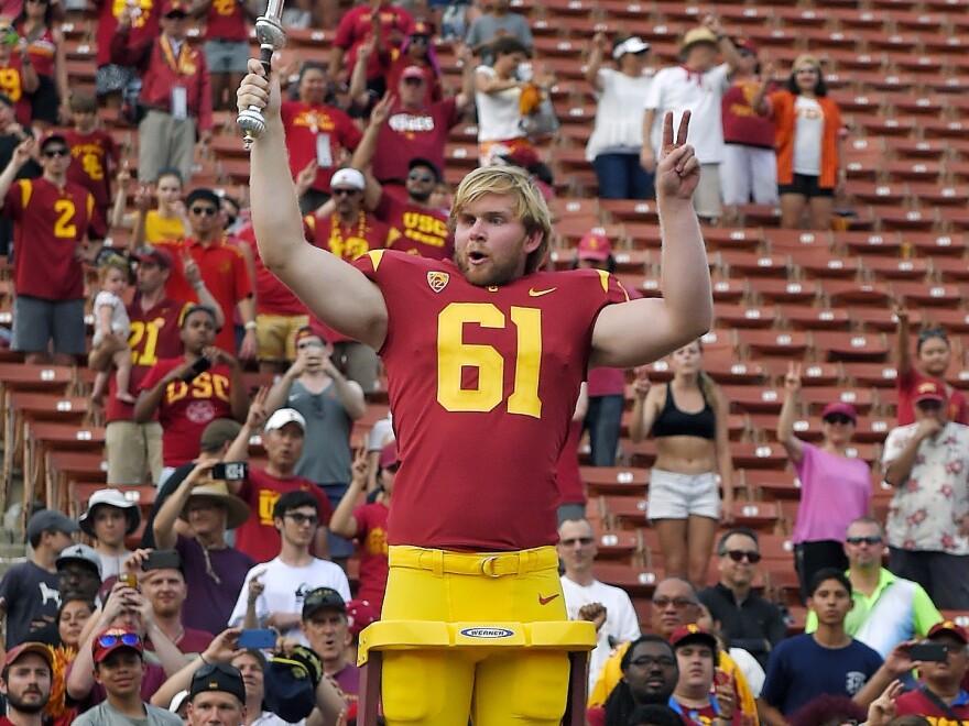 USC long snapper Jake Olson leads the Trojan Marching Band following a victorious game against Western Michigan on Saturday.