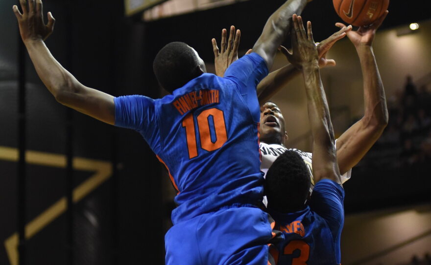 Florida defenders Dorian Finney-Smith (10) and Kevarrius Hayes (13) double team Vanderbilt's Damian Jones (30) as he goes up for a shot in the first half. (Greenberry Taylor/WUFT News)