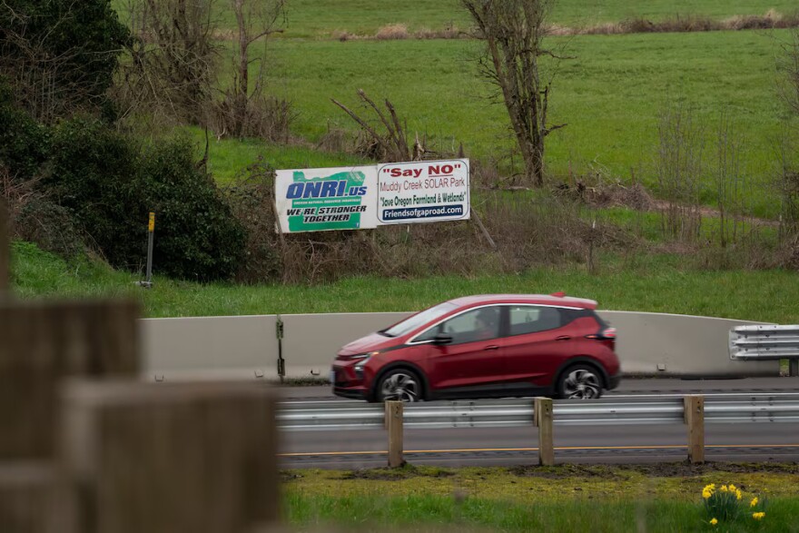 A sign advocating against the Muddy Creek solar project is on the Interstate 5 highway near Harrisburg, Ore.