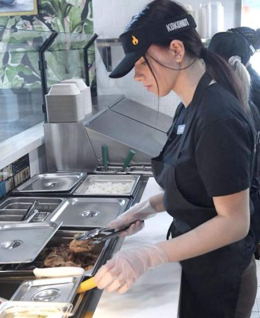 Kassidy Gibbons serves food during training at Kokonut Island Grill on Wednesday in Logan.