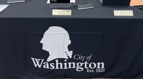 a black banner with a white silhouette of former President George Washington and an inscription that reads City of Washington Est. 1825