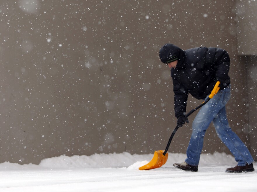 In Denver, Cole Baldock shovels snow on Wednesday morning.
