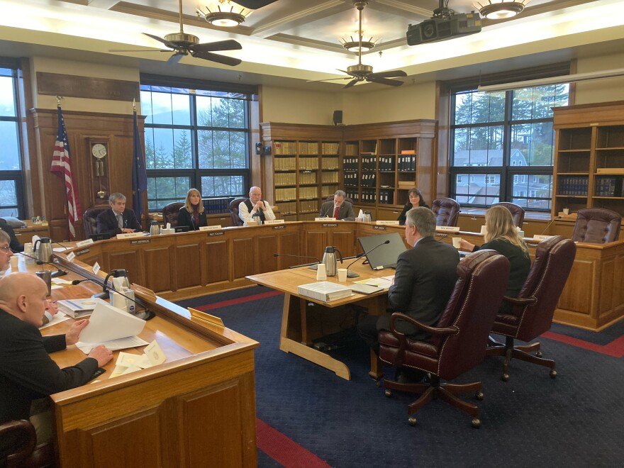 Lawmakers and others seated in a Capitol committee room