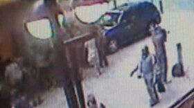 A frame made from a surveillance video released Monday by the New York Police shows a man, upper right, removing a shirt in an alleyway near Times Square as people walk by him.