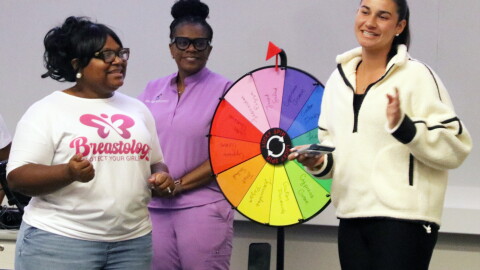 Nicole Miller, left, founder of Blossoming Butterfly Inc., on stage with a member of STOP Cancer, asking the group trivia questions about her presentation. (Catherine Chapman/WUFT News)