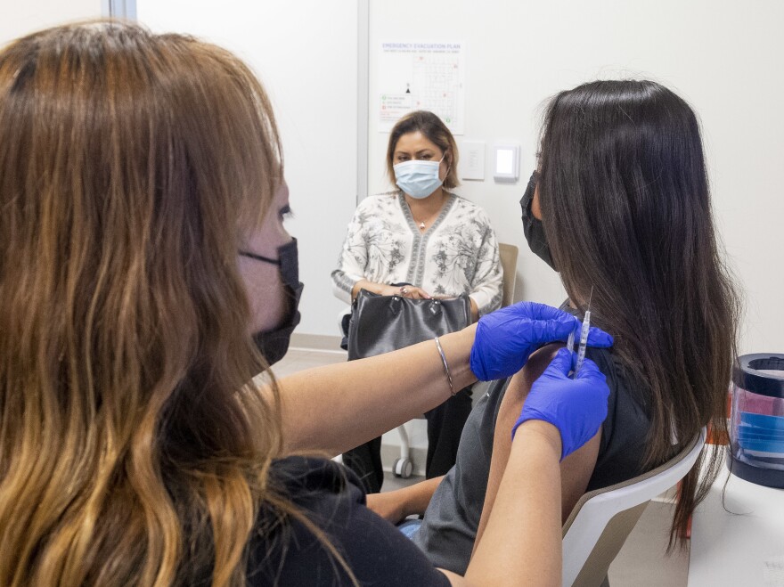 A 16-year-old gets a Pfizer-BioNTech COVID-19 vaccine in Anaheim, Calif., on April 28. Advisers to the Centers for Disease Control and Prevention now say it's not necessary for adolescents to wait two weeks after a COVID shot to receive routine immunizations.