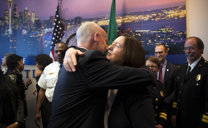 Tim Burgess hugs Seattle Police Chief Kathleen O'Toole after a press conference on Monday, December 4, 2017, at Seattle City Hall. 