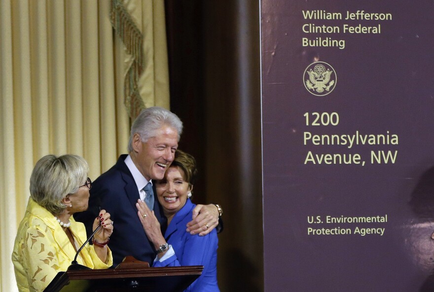 Former President Bill Clinton hugs House Minority Leader Nancy Pelosi of California as another Democrat, Sen. Barbara Boxer of California, looks on at Wednesday's ceremony naming the Environmental Protection Agency headquarters for him.