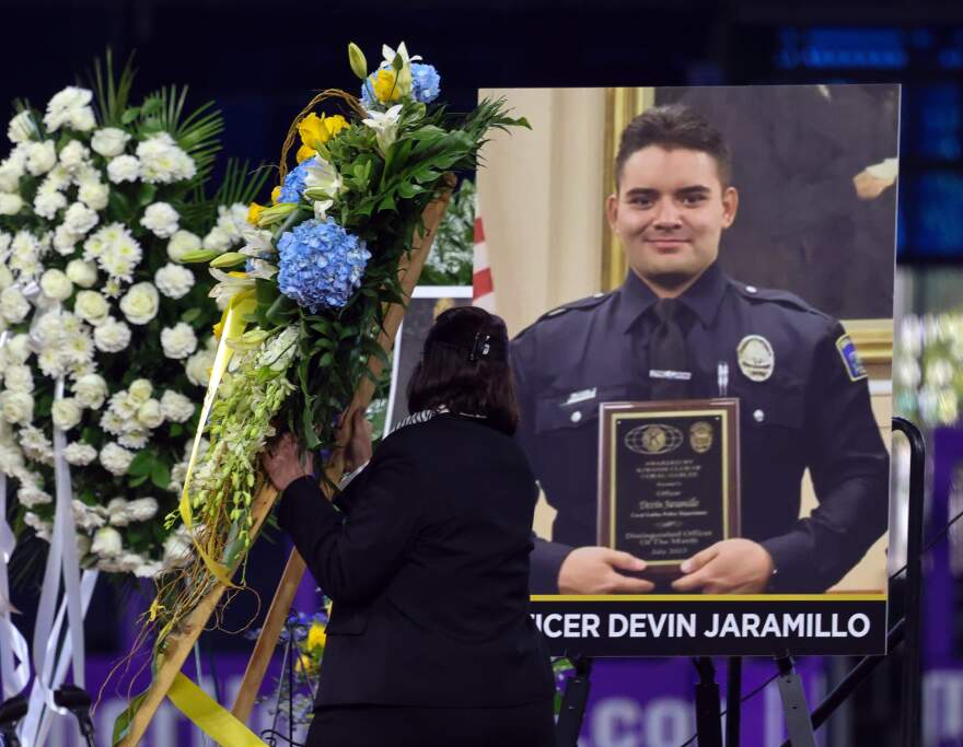 A wreath of flowers is placed next to the photo of Miami-Dade Deputy Sheriff Devin Jaramillo in preparation of his funeral service at loanDepot Park, where law-enforcement officers, public servants, friends, and family members gathered to honor the fallen deputy on Tuesday, Nov. 18, 2025, in Miami, Florida.