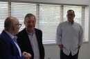 Dick Durbin stands with a man directly to the left and another slightly behind to the right of the camera. All are laughing.