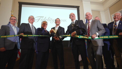 Daniel J. Santaniello, Fidelity Bank President and Chief Executive Officer, cuts a ribbon to open the bank's new corporate headquarters alongside Pennsylvania Governor Josh Shapiro and other bank and elected officials.