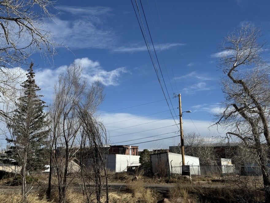 Powerlines are shown crisscrossing a blue sky.