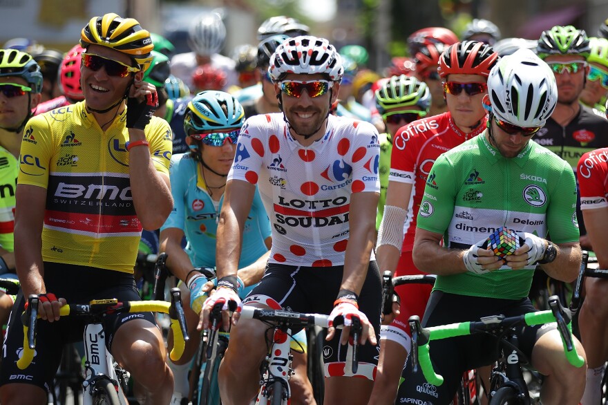 Mark Cavendish of Great Britain works on a Rubik's Cube on the start line prior to stage seven of the 2016 Tour de France.