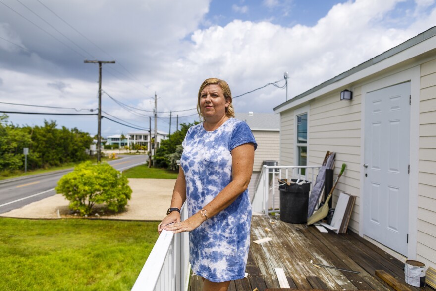 Amy Tripp at her new home in Big Pine Key, Florida. She closed early to buy it before federal flood insurance rates rose by thousands of dollars. Her rate will still go up more slowly over time. [Saul Martinez for NPR]