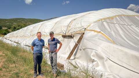 Utah Olympic Legacy Foundation Chief Operating Officer Calum Clark (left) and Soldier Hollow Nordic Center Operations Manager Bill Pierce stand next to an artificial “glacier” of last season’s snow wrapped in an insulating blanket, July 30, 2026. A proof-of-concept project this year, the goal is to see if preserving snow over the summer to lengthen the winter ski season is feasible in a place like Utah.