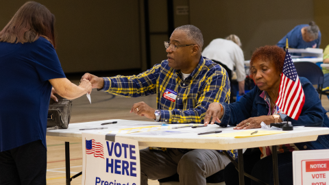 Saginaw Township poll workers Vincent McMillon and May Wathen help a voter prepare to cast her ballot in the Aug. 4, 2026 primary election.