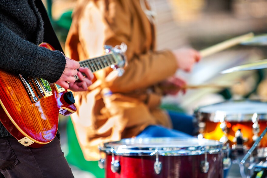 Festival music band. Hands playing on percussion instruments in city park . Drums with sticks closeup. Body part of male musicians. 