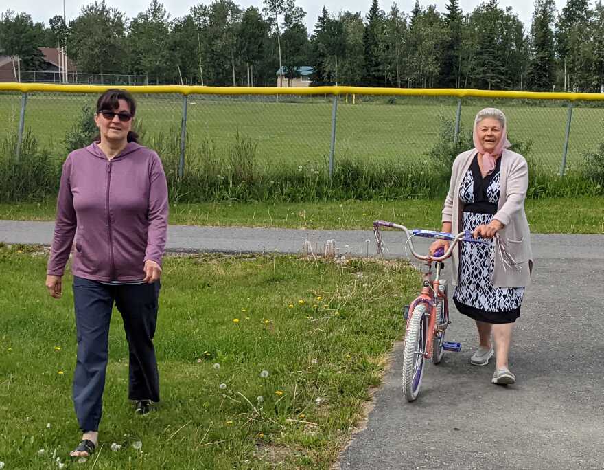 Olga Barladyan, left, and her mom, Luba, return from a test drive in which Luba tried out a kids bike. She rode it around a bike path at the park, but decided the seat was too small and uncomfortable. So she checked out other bikes brought to the event by College Rotary board member Pam Flory and her husband, Glenn Potts.