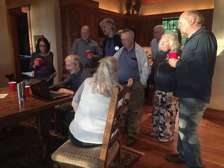 Members of Water For Flathead's Future watch a documentary on water bottling at a potluck Wednesday night.