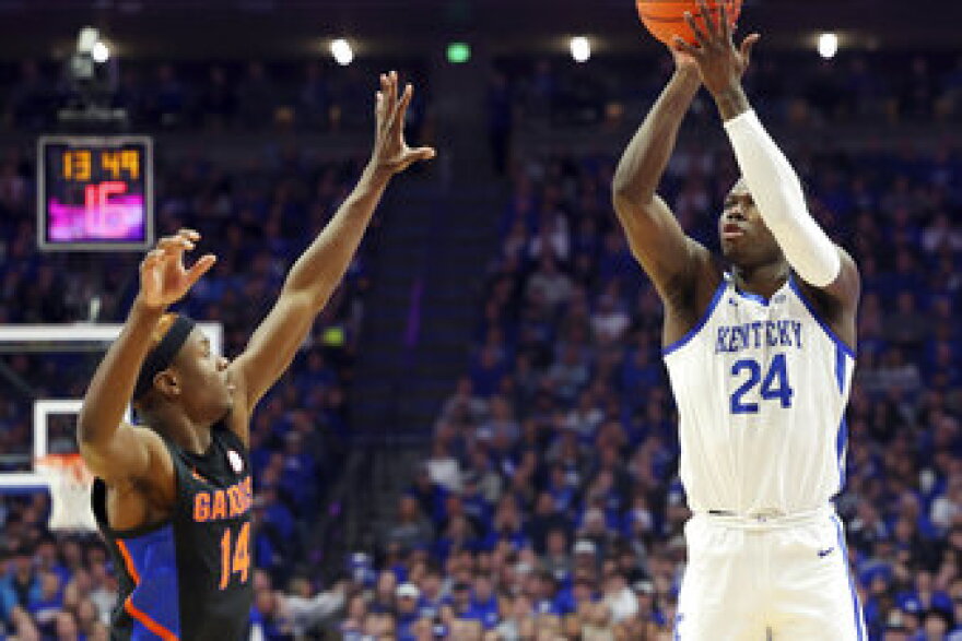 Kentucky's Chris Livingston (24) shoots while defended by Florida's Kowacie Reeves (14) during the first half of an NCAA college basketball game in Lexington, Ky., Saturday, Feb. 4, 2023. (AP Photo/James Crisp)