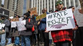 Yessenia Balcazar of the Southeast Environmental Task Force holds a sign at a March 27 protest of Peoples Gas’ proposed rate increase in downtown Chicago.