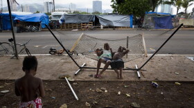 In this 2015 photo, two children rest on a hammock at a homeless encampment in the Kakaako district of Honolulu. Homelessness in Hawaii has grown in recent years, leaving the state with 487 homeless per 100,000 people, the nation's highest rate per capita, according to federal statistics. (Jae C. Hong/AP)