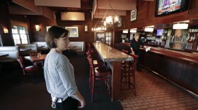Lauren Durchslag, general manager at the Tap Room at Dubsdread golf course, checks on things before opening for business on Monday, May 4, 2020, in Orlando, Fla. Many Florida restaurants were allowed to open today with outdoor tables six feet apart and indoor seating at 25% capacity. (AP Photo/John Raoux)