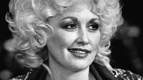 Country singer Dolly Parton talks with reporters and well-wishers at a rehearsal session in Nashville, Wednesday, Nov. 11, 1982. Making a comeback after surgery, Parton will open her act November 19 in Atlantic City, New Jersey. (AP Photo/Mark Humphrey)