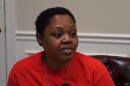 A woman with short, black hair and a red shirt.