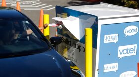 A voter inserts a ballot in a drive-up drop box last week in Renton, Wash., in that state's primary.