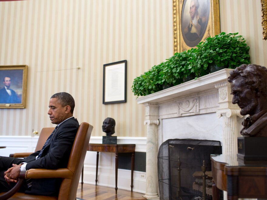 President Obama is seen during a September meeting at the White House, juxtaposed with the paintings of Abraham Lincoln and George Washington, busts of Martin Luther King Jr. and Abraham Lincoln, and the Emancipation Proclamation.