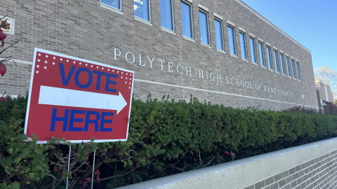 A sign reads "vote here" in front of Polytech High School of Kent County.