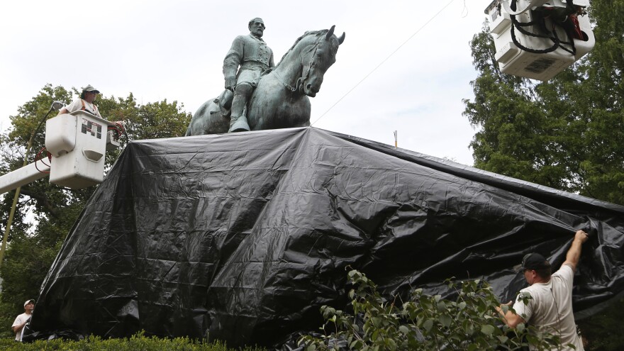 City workers drape a tarp over the statue of Confederate General Robert E. Lee in Charlottesville, Va. on Aug. 23, 2017. [Steve Helber / AP]