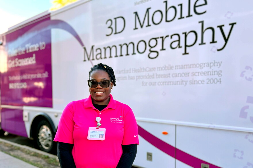 Shanae Grant stands in front of the bus that drives around CT offering mammography services as part of Hartford Hospital's "Take the Time” Mobile Mammography Program. Grant is the Community Outreach Specialist for the program. She said the bus visits public and private places across the state to offer services where people may not have access to this kind of health care treatment.